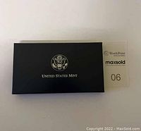 Closed black United States Mint presentation box with emblem on lid.