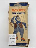 Original box of vintage roller skating monkey marionette by Peter Puppet with worn edges, creases and tears visible. Box features illustration of the monkey and text including 'Monkey Marionette', 'A Peter Puppet Product', and 'Simple Unitrol 1 Hand Control'.