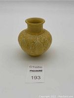 Front view photo of the yellow Rookwood vase showing the leaves and berries design and shape.