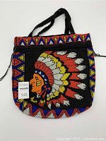 Front view of vintage black beaded bag showing colorful Native American Chief head motif and geometric patterned borders with two black beaded handles.