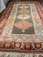 Full view of rectangular area rug laid on wood floor showing central medallions and borders