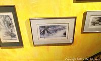 Three framed Asian themed artwork prints hanging on a yellow wall, varying sizes and horizontal and vertical orientations shown.