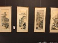 Four framed vertical landscape paintings displayed side by side on a wall