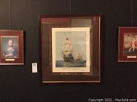 Wall display showing largest framed ship artwork print with two smaller framed artwork prints on either side