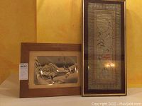 Two framed art pieces displayed side by side, showing size and overall condition