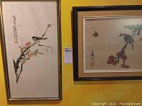 Overview of two framed Asian themed artworks side by side on wall