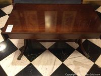 Full top view of rectangular wooden coffee table with drop leaves deployed, showing polished brown finish and glossy surface.