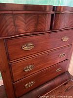 Front view of the dresser showing three drawers with brass oval handles and wood grain finish.
