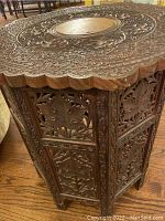 Full view of the carved wooden folding side table in open position