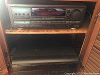 Full view of stereo receiver on shelf above compact disc changer