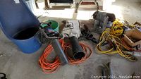 Photo of Toro electric leaf blower, orange extension cord, and a blue plastic container