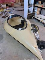 Side view of beige Micro Poke Boat hull with black trim and wheels