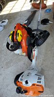 Stihl FS56RC edger/trimmer and Stanley ear protector on garage floor