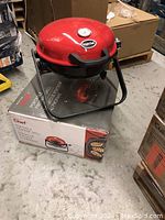 Photo of the red dome-shaped portable propane gas grill on its original product box, visible Bright Club and Master Chef branding.