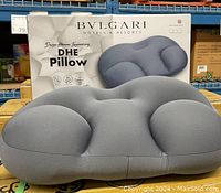 Front view of the Bvlgari DHE Pillow with the product box behind it, showing the shape and color of the pillow.