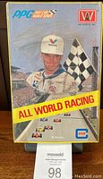 Front face of the sealed box showing racing driver and branding.