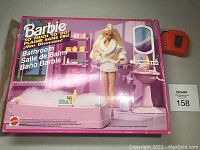 Front view of original Barbie Bathroom kit box showing doll in bathrobe with bathtub, sink, and shelves with accessories in background.