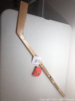 Full view of the 42-inch child-size wooden hockey stick lying flat on a white table, showing the stick's length and the text marking on the shaft.
