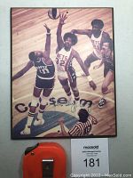 Framed sepia-tone basketball action photo with Julius Erving in a Nets jersey, featuring his autograph near the bottom center.