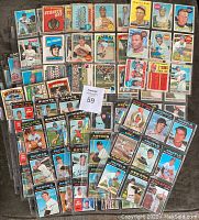 Wide view of assorted baseball cards arranged in piles and some enclosed in plastic sleeves showing diverse players and team logos from O.P.C. Canada and Topps brands