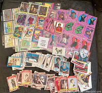 Wide view of various trading card stacks and spreads including Star Wars, Superman, Michael Jackson and others.