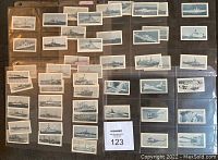 Photo of a collection of about 46 black and white Navy ship cards, organized in plastic card sleeves, showing various warships and naval vessels.