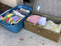 Overview of all items showing a blue tote with folded blankets and a wooden chest with folded towels and a floral quilt