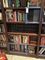 Books arranged in three shelf areas bordered by blue tape showing medical and health topics.