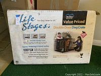 Full view of the boxed dog crate showing branding, size and highlighted features including divider panel, double doors, and portability.