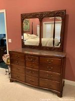 Full view of dresser with glass top and matching carved wood framed mirror