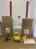 Three Enesco resin figures in front of original boxes