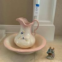 Full view of the wash basin and pitcher with the figurine beside it