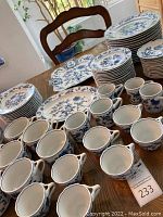 Overall view of stacks of plates, cups and mugs on wooden table