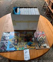 Individual comic books placed out in front of the box, includes visible titles Sin City: The Big Fat Kill, The Strangers, and others