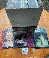 Box of various comic books with visible titles on covers