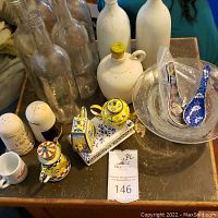 Overall lot with three Kelvin Chen teapots, multiple glass and ceramic bottles, and small tea set with gnomes visible.