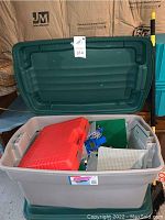 Open plastic storage tub showing lid and mixed contents