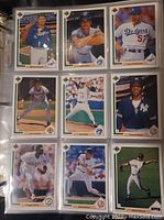 Close view of nine baseball cards displayed in a page protector binder sleeve showing images of players in 1991 Upper Deck series.