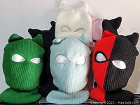 Photo showing six knit ski masks in various colors with eye holes and ear-like points