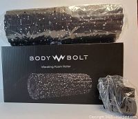 Photo showing new or open box like new Body Bolt vibrating foam roller wrapped in plastic, its original box and charger included.