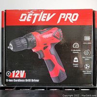 Front of the original box displaying the red and black Detiev Pro 12V Li-ion cordless drill driver, highlighting 2 adjustable speeds, 12V battery, max torque 28Nm, max speed 1200 RPM, and weight of 1.5 KG.