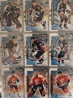 Close-up of six Dynacon Ice hockey cards showing players in action poses wearing black jerseys with hockey sticks.