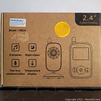 Front of HelloBaby baby monitor box showing model HB24, 2.4 inch colour display, and features such as 8 lullabies, night vision, two-way communication, temperature display.