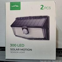 Box of a Litom 2 piece 300 LED solar motion sensor lights showing product image and details.