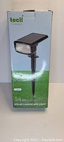 Photo of the boxed Tocll solar landscape light with a picture of the light, showing brand, product type and 34 LEDs.