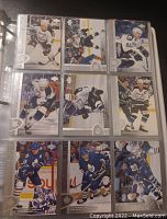 Binder page showing hockey cards in plastic sleeves featuring players in game action from the 95-96 Upper Deck series.