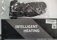 Photo shows a pair of black Snowdeer electric heated mittens in plastic packaging resting on a black box labeled "Intelligent Heating".