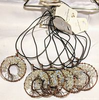 Seven round copper tree pendants with natural opal chip stones on black cord necklaces.