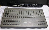 Photo showing both items: black rackmount American DJ CC-100 controller and the larger NSI MC 1616 memory lighting controller with 16 sliders and multiple buttons.