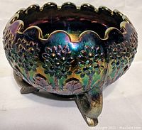 Side view of Fenton carnival glass bowl showing scalloped edge and raised floral pattern on iridescent surface
